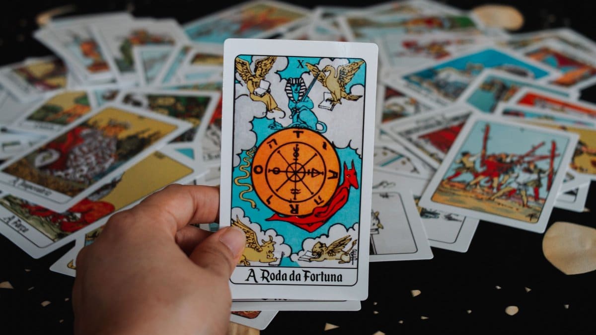 Close-up of a hand holding a tarot card in a deck for a fortune-telling session.