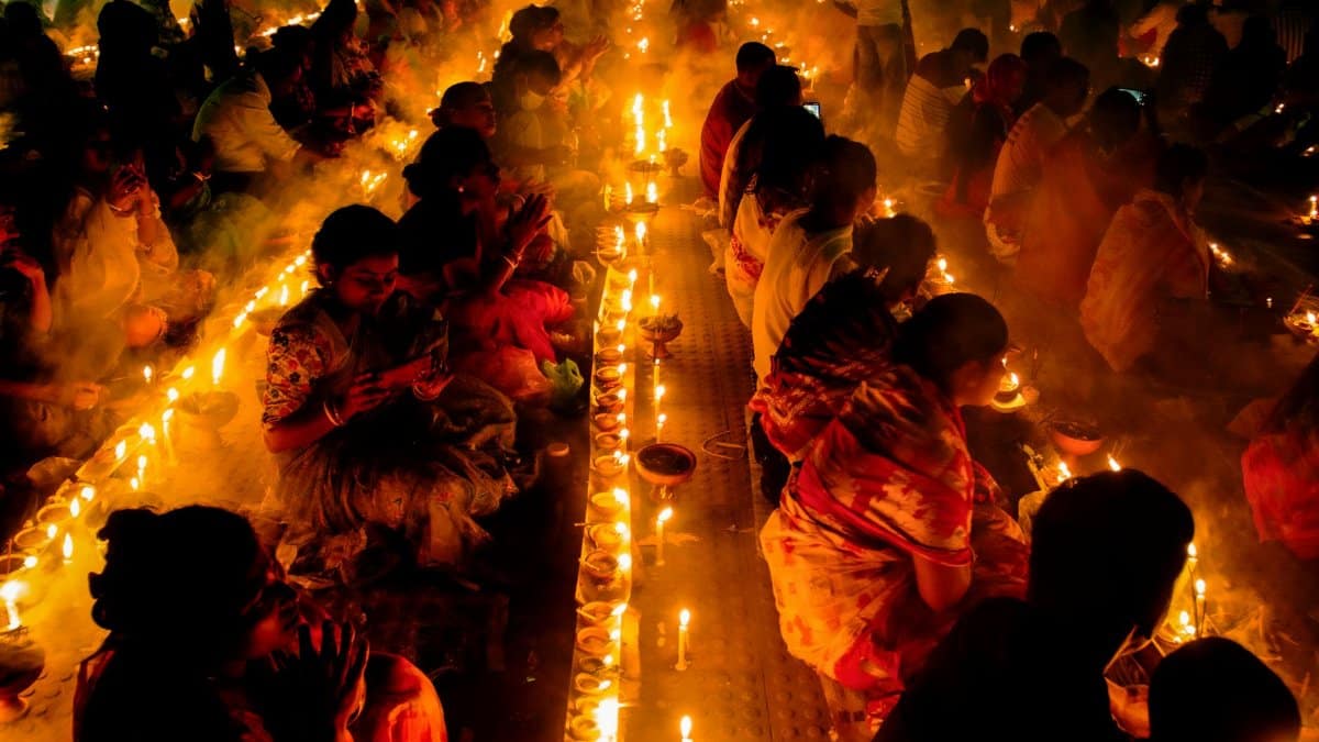 A cultural event in Narayanganj, Bangladesh with people gathered around candlelight, creating a warm and spiritual ambiance.
