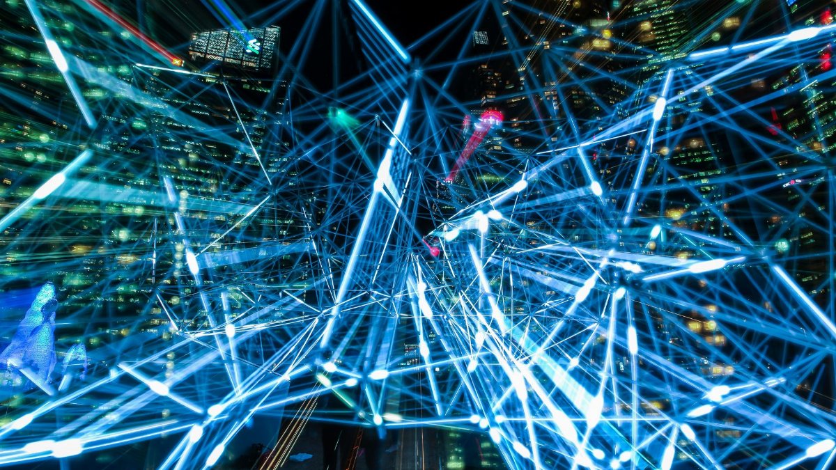 Dynamic urban scene showcasing interconnected light trails representing digital communication networks.