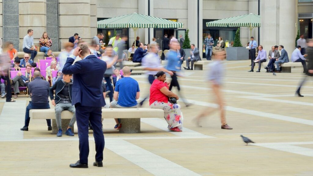 People in motion at Paternoster Square, capturing vibrant city life near St. Paul's Cathedral, London.