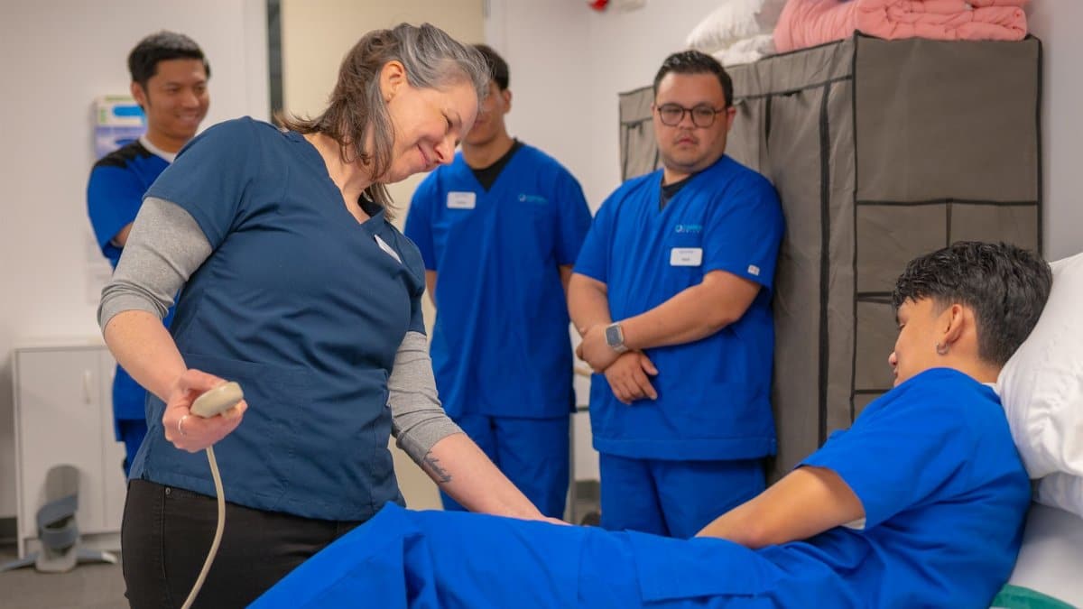 Healthcare professionals in a training session using medical equipment indoors.
