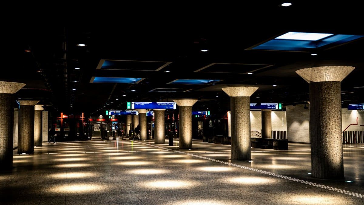 A well-lit urban subway station with concrete columns and modern architecture.