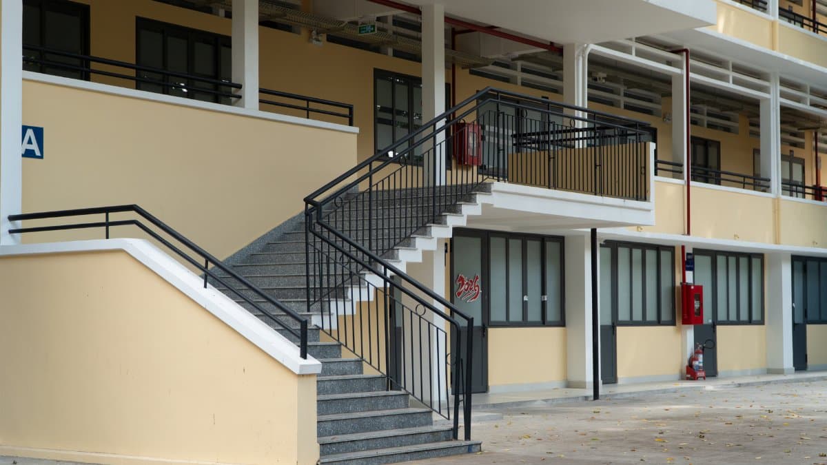 Outdoor staircase at modern school building featuring metal railings and multiple floors.