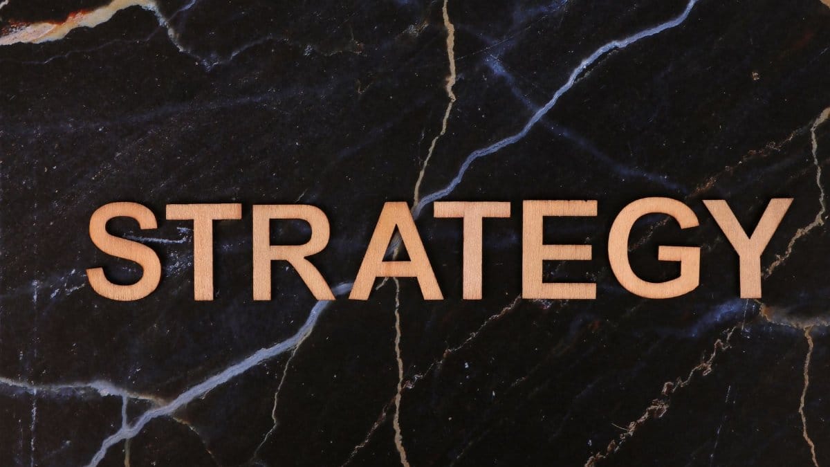 Strategic planning concept with 'Strategy' in wooden letters on dark marble.