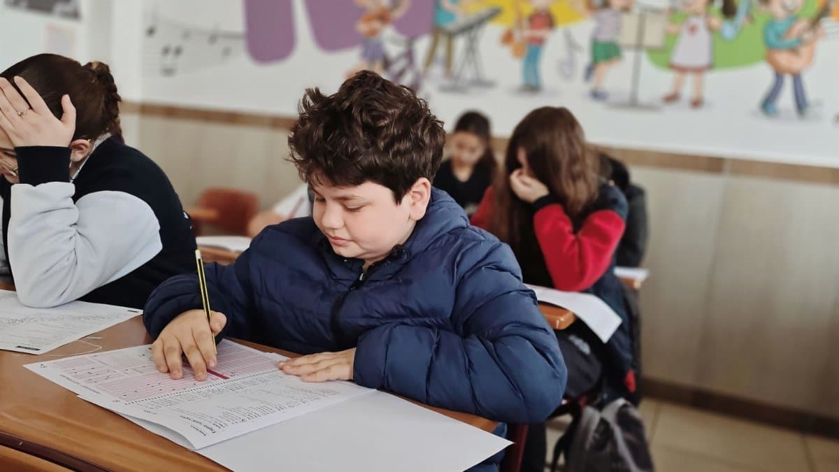 A group of children taking a test with focus and concentration in a classroom setting.