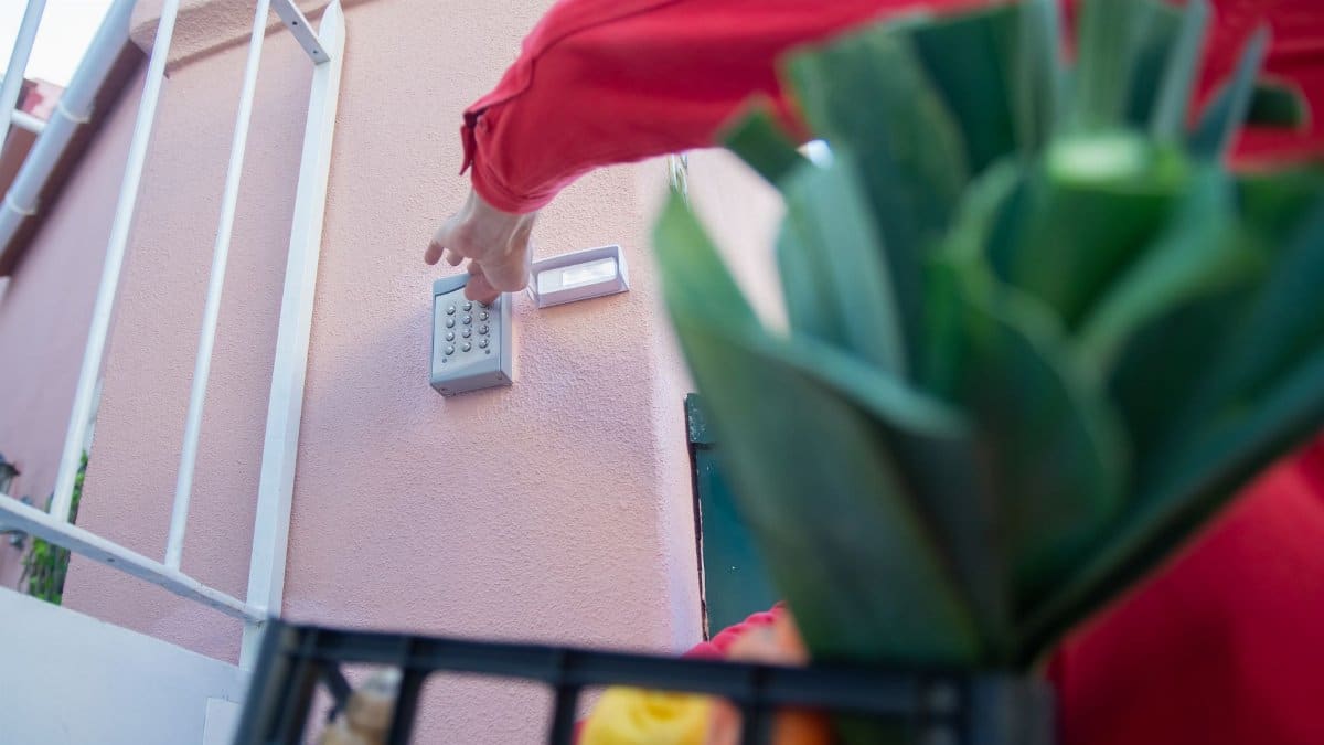Close-up of a person using a security keypad on a gate, highlighting home access control.