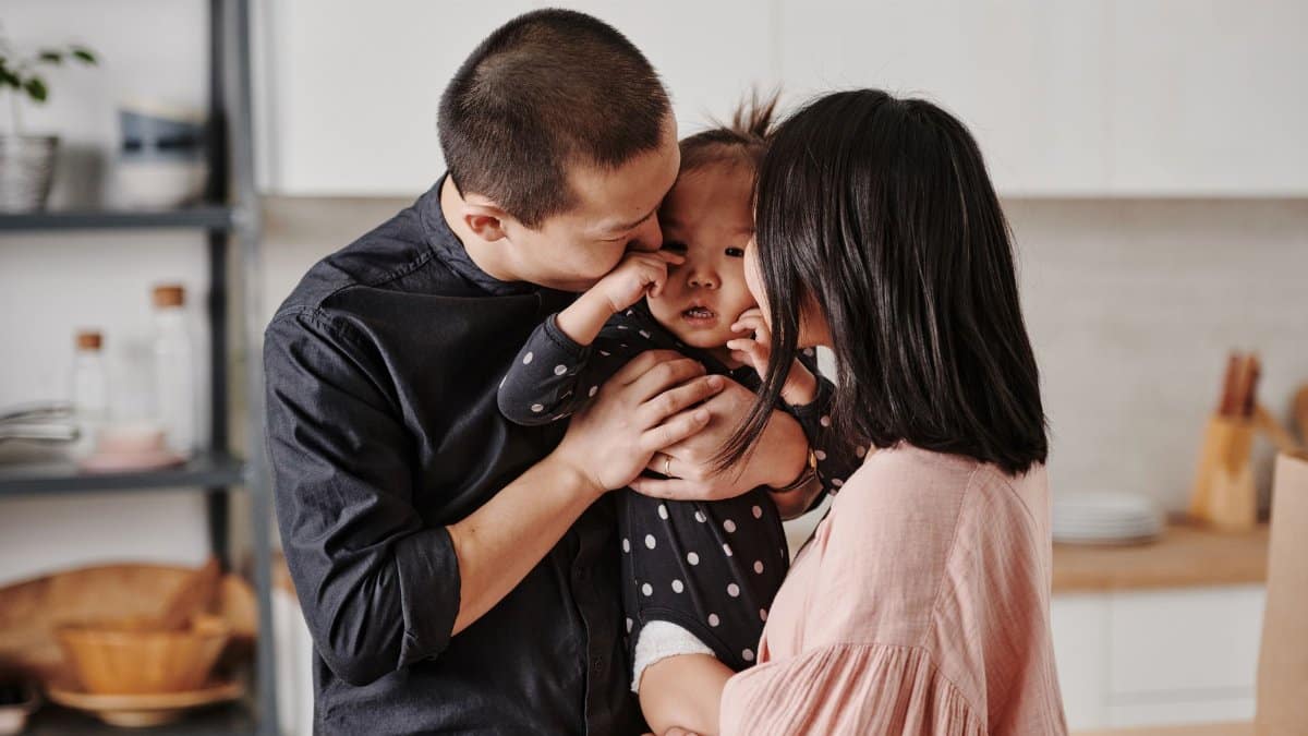 A loving Asian family shares a tender moment in their modern kitchen.