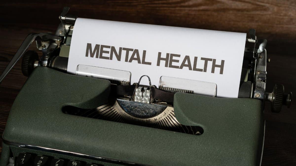 Close-up of a vintage typewriter displaying a mental health message on paper.