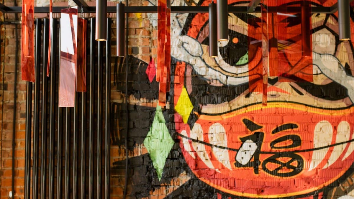 Colorful graffiti mural with modern hanging lights creates a vibrant urban art decor.