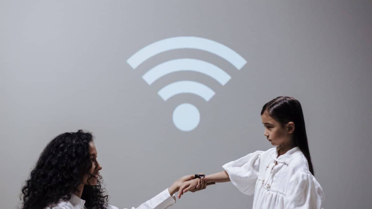 A mother and daughter holding hands with a Wi-Fi symbol, symbolizing modern connection.