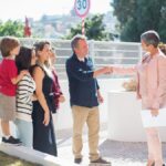 Family meets real estate agent outside home in Portugal, negotiating property deal.