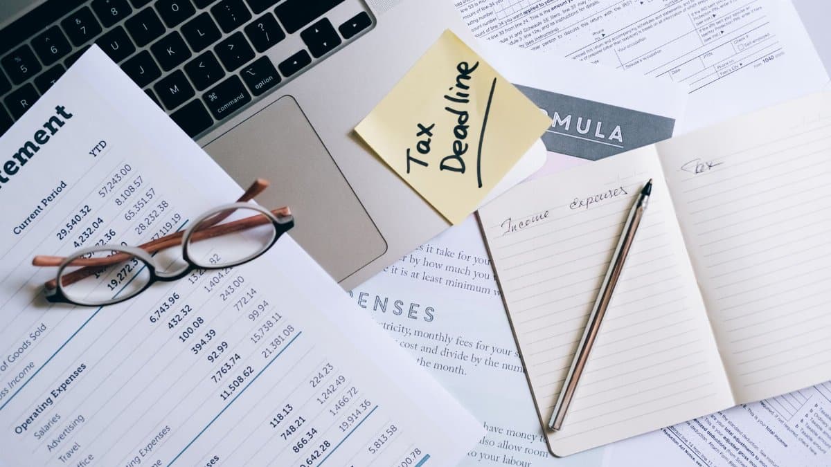 Workspace with laptop, documents, and tax deadline note for financial management.