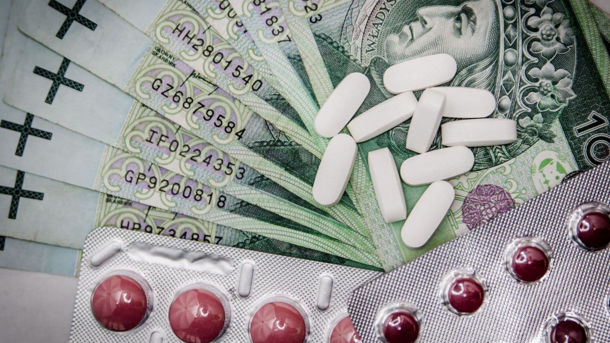 Polish 100 złoty notes with pills and blister packs, illustrating medical costs.