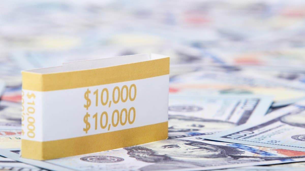 Close-up of a stack of $10,000 US dollar bills with a currency strap on a background of paper money.
