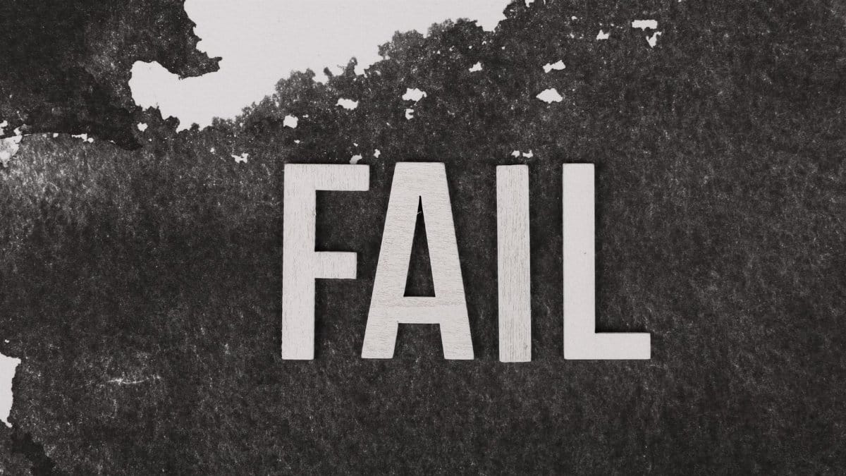 Grayscale image of the word 'FAIL' on a textured, monochrome background.
