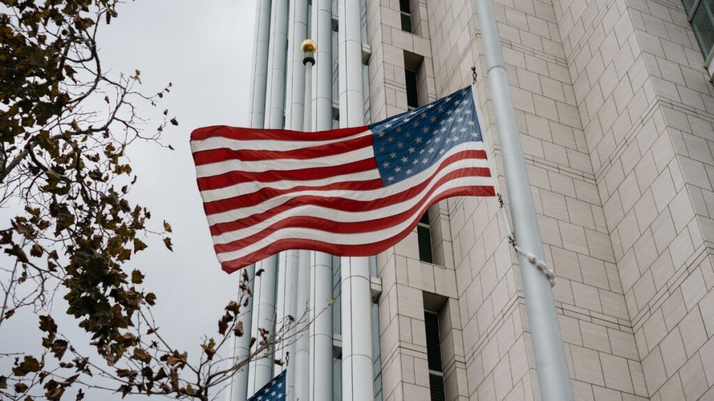 Low angle of American flag waving in front of a government building in Anaheim, CA.