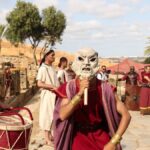Actors in Roman attire perform at historic ruins in Morocco, blending culture and history.