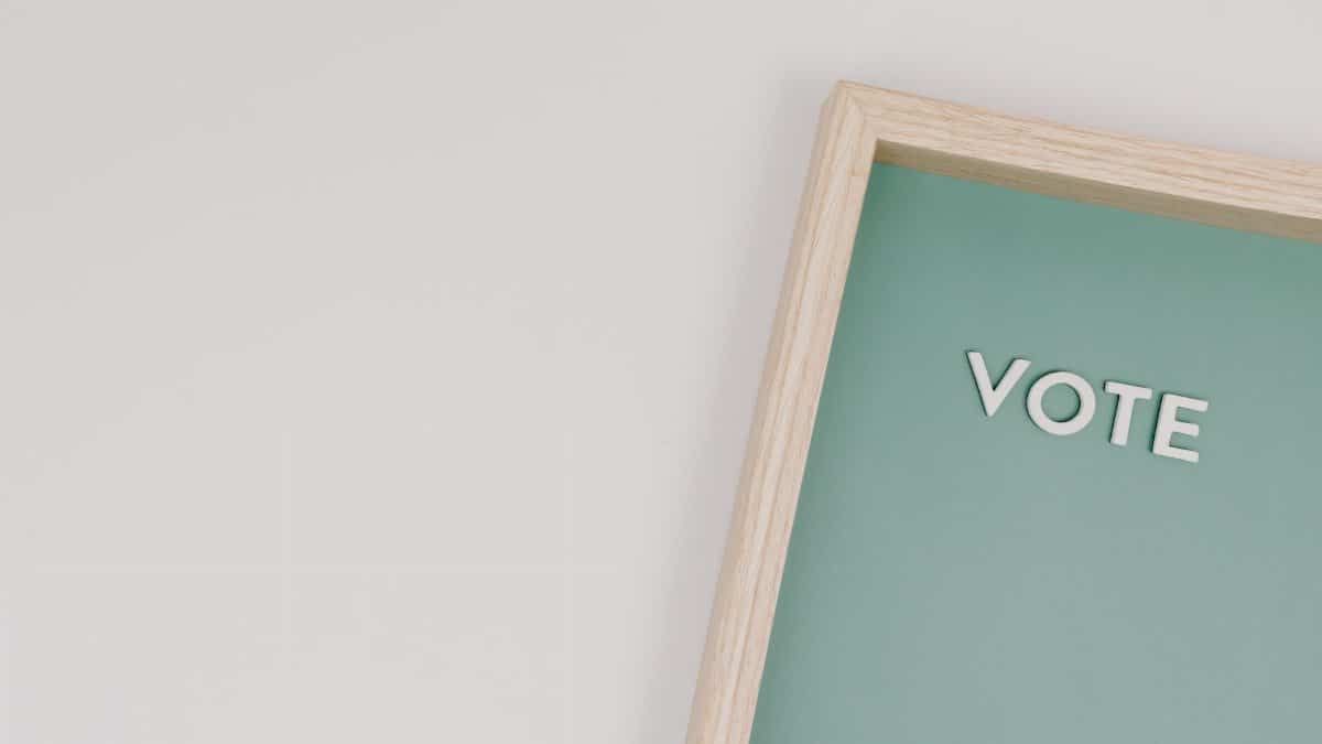 Elegant wooden frame with 'Vote' on a green background, perfect for election themes.