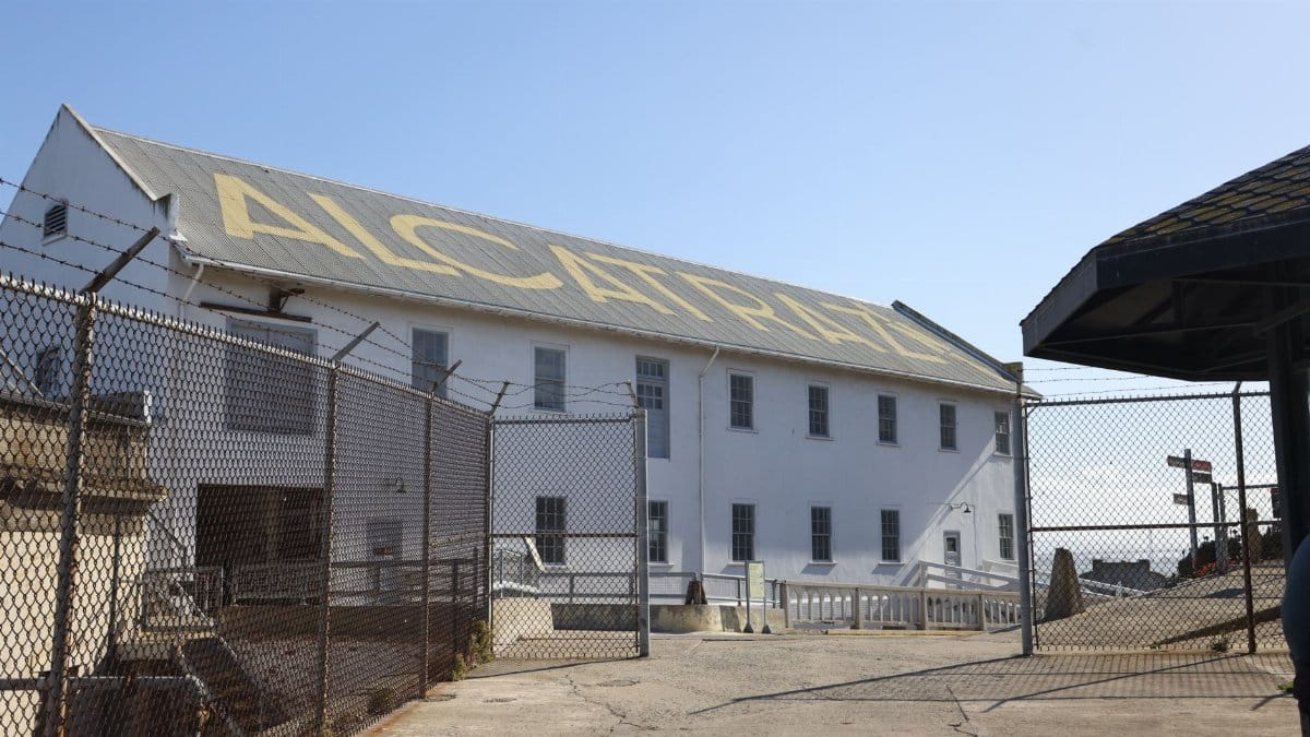 Exterior view of Alcatraz Island prison building under clear blue sky.