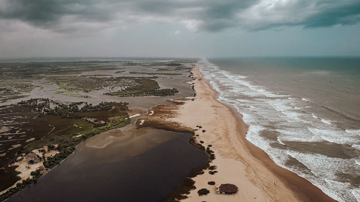 A stunning aerial shot capturing a vast coastal landscape under a moody sky.