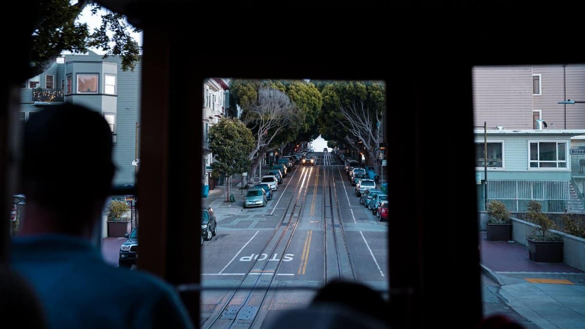 A scenic view of San Francisco streets from inside a moving cable car, highlighting urban transportation.