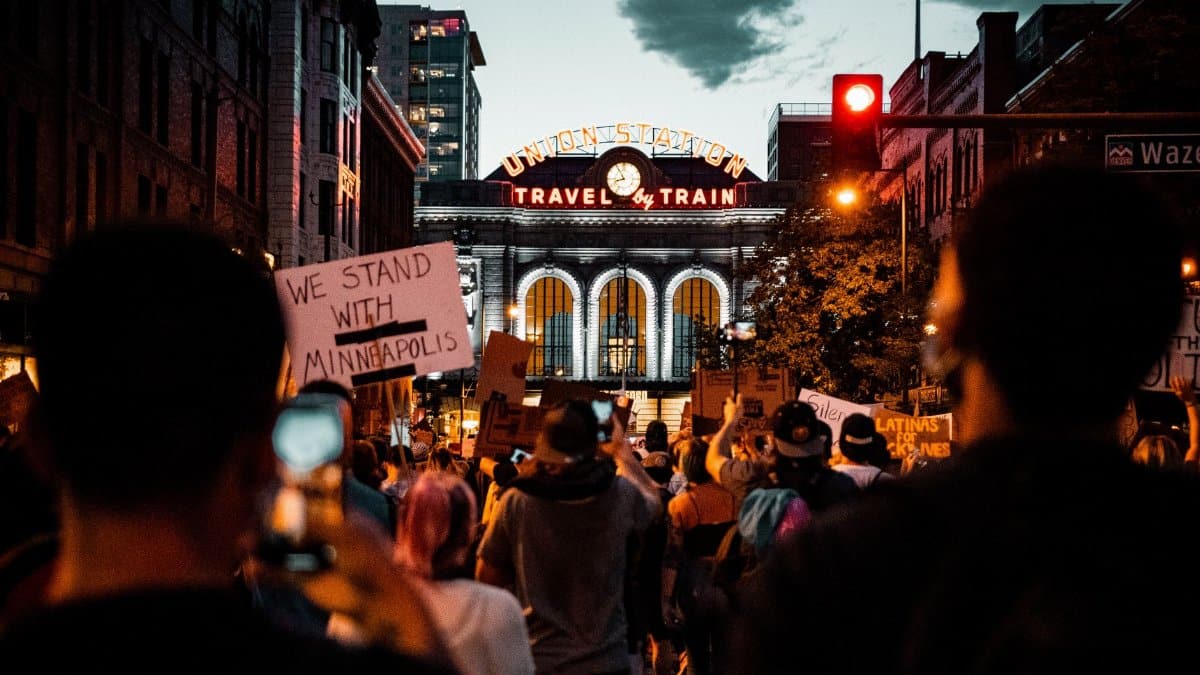 A protest at Denver's Union Station with signs supporting Minneapolis, captured at night.