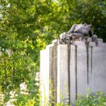 A tranquil statue surrounded by lush greenery in a New York garden setting.
