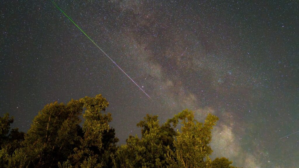 Stunning night sky in Graz, Austria featuring a meteor shower and the Milky Way.