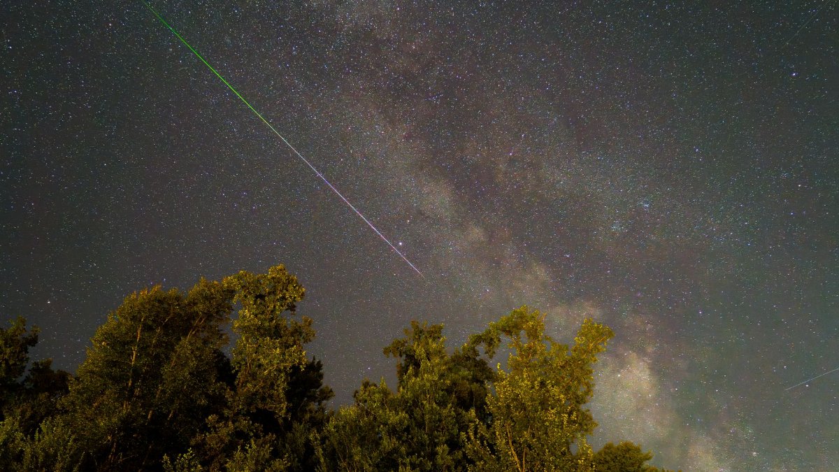 Stunning night sky in Graz, Austria featuring a meteor shower and the Milky Way.
