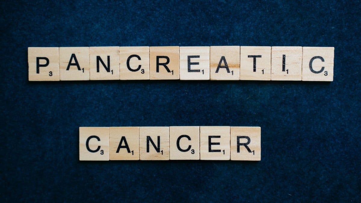 Wooden tiles spelling 'Pancreatic Cancer' on a textured blue background.