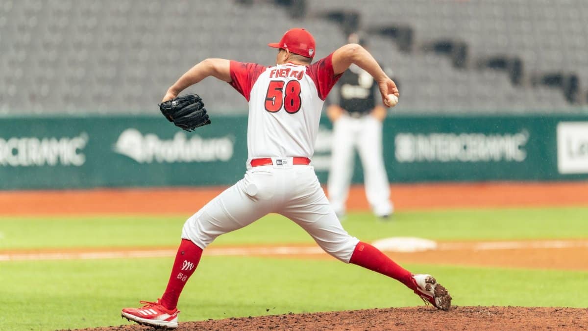 Dynamic image of a baseball pitcher delivering a throw during a game at a spacious stadium.