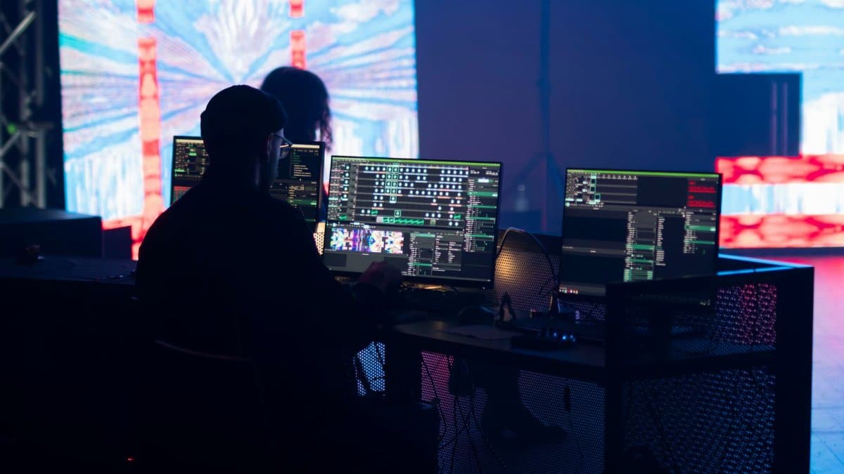 A stage technician monitors multimedia displays during a live event setup.