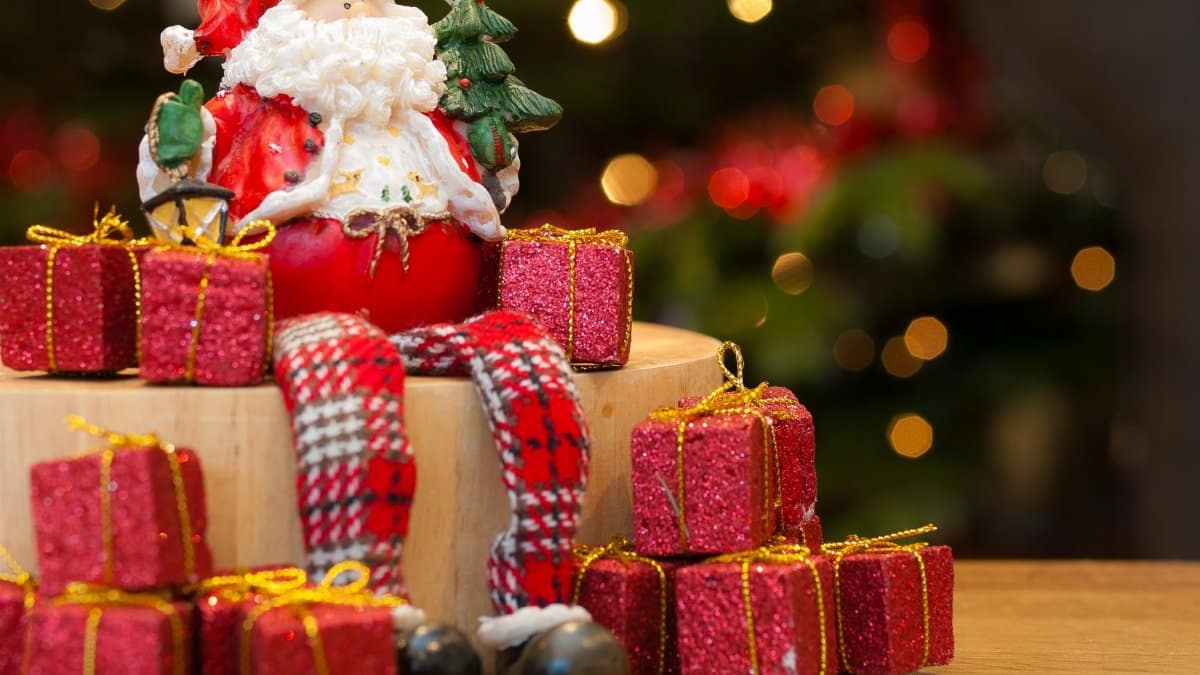 A cheerful Santa Claus figurine surrounded by festive gifts, perfect for Christmas decor and holiday spirit.