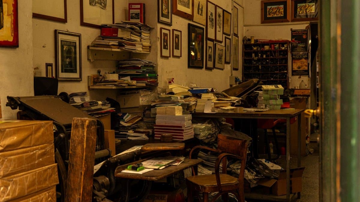 A cluttered vintage print shop interior in Florence, Italy, filled with books and artwork.