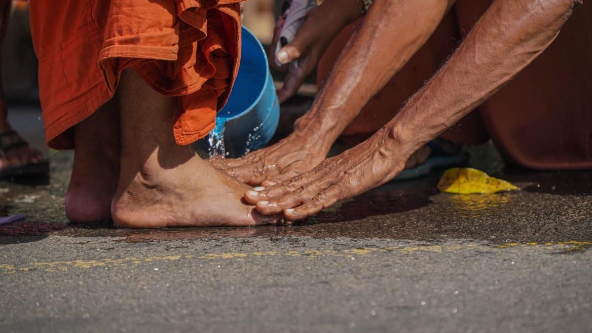 A close-up of a traditional Buddhist foot washing ritual during a ceremony in Sri Lanka, showcasing devotion and respect.