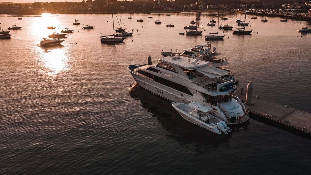A luxurious yacht docked in Newport, RI marina during a serene sunset. Perfect for travel and lifestyle themes.