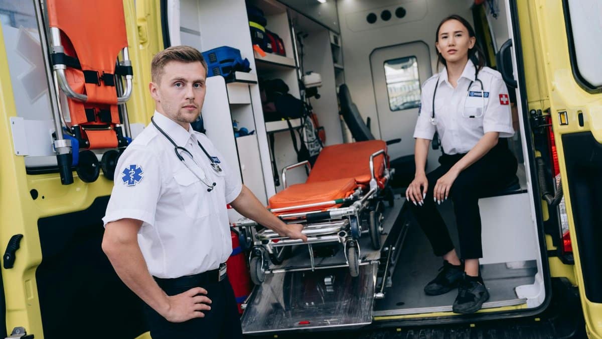 Paramedics prepare for an emergency with medical equipment in an ambulance.