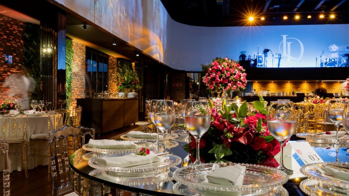 Luxurious wedding venue with detailed table settings, glassware, and vibrant floral arrangements.