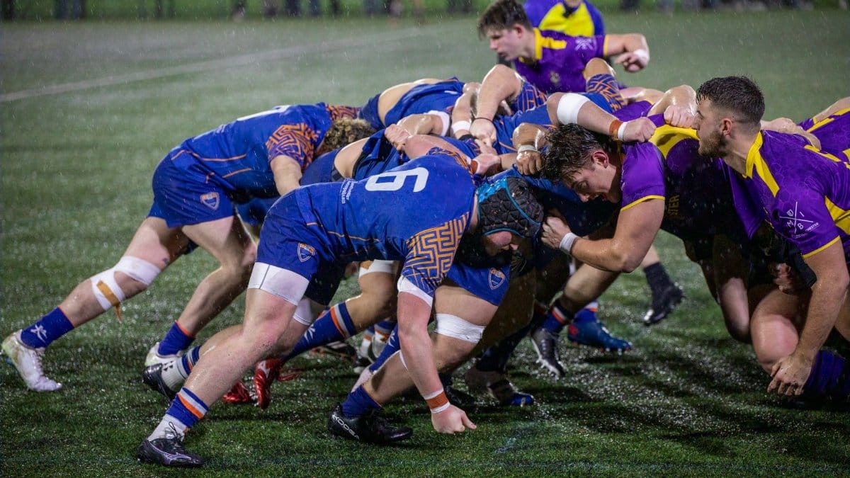 A dynamic rugby scrummage during a match in Manchester, England.