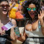 Two women joyfully participating in the colorful New York Pride Parade.