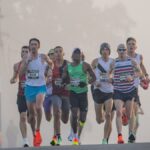Dynamic shot of marathon runners competing in a misty urban setting, emphasizing endurance and athleticism.