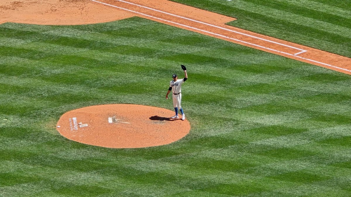 Aerial view of a baseball pitcher on the mound during a game in Seattle, WA under sunny skies.