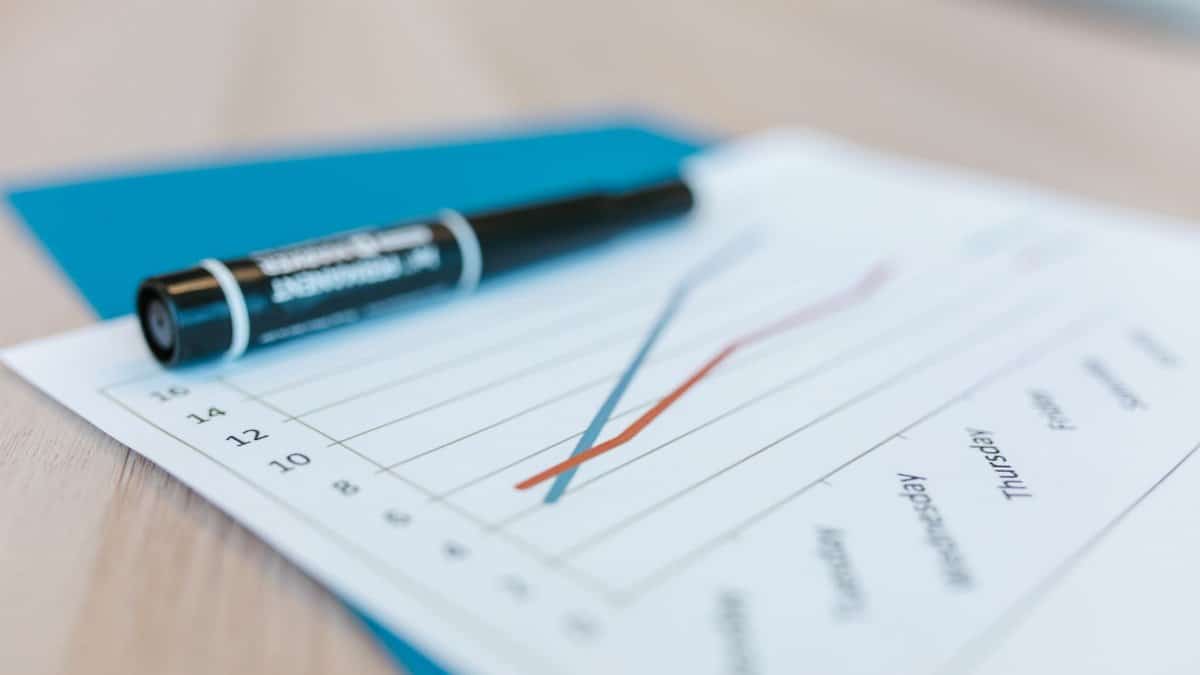 Dynamic line chart on paper with black marker on a desk, illustrating data trends.