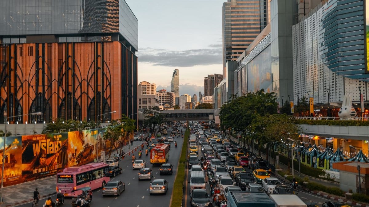 Vibrant cityscape of Bangkok at dusk with bustling traffic and skyline in view.