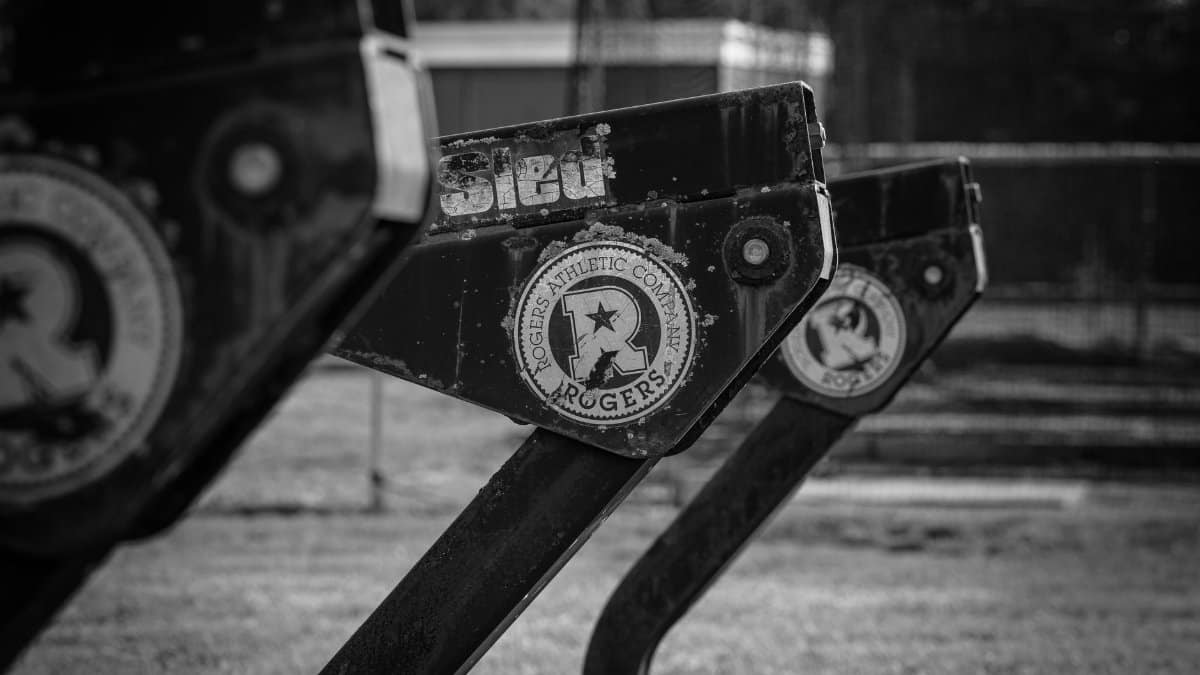 Monochrome image of Rogers Athletic Company sports sled equipment outdoors.
