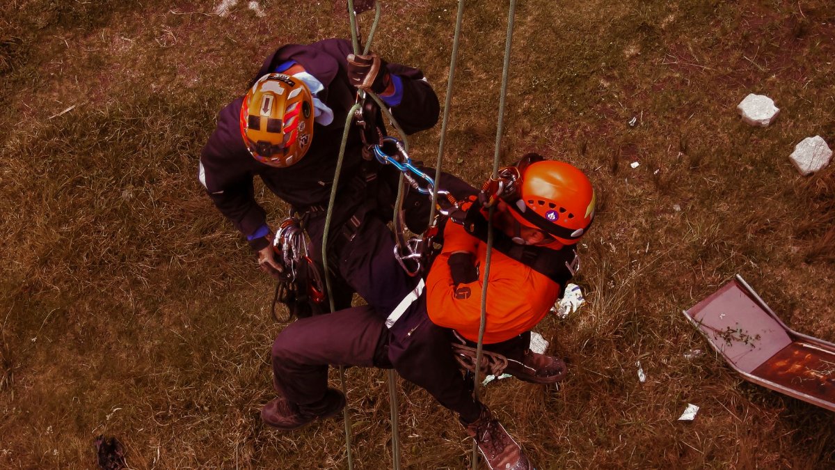 Rope access professionals engaging in technical rescue training during a daring outdoor adventure.