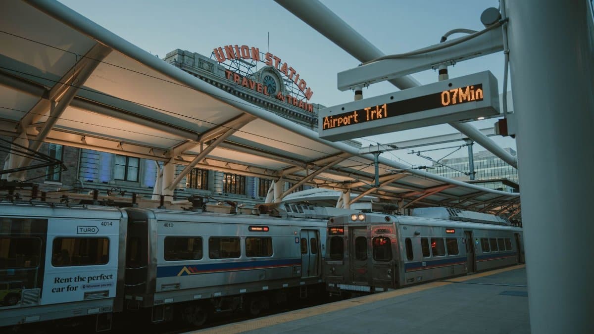 Evening train at Denver Union Station with iconic sign and transit information display.