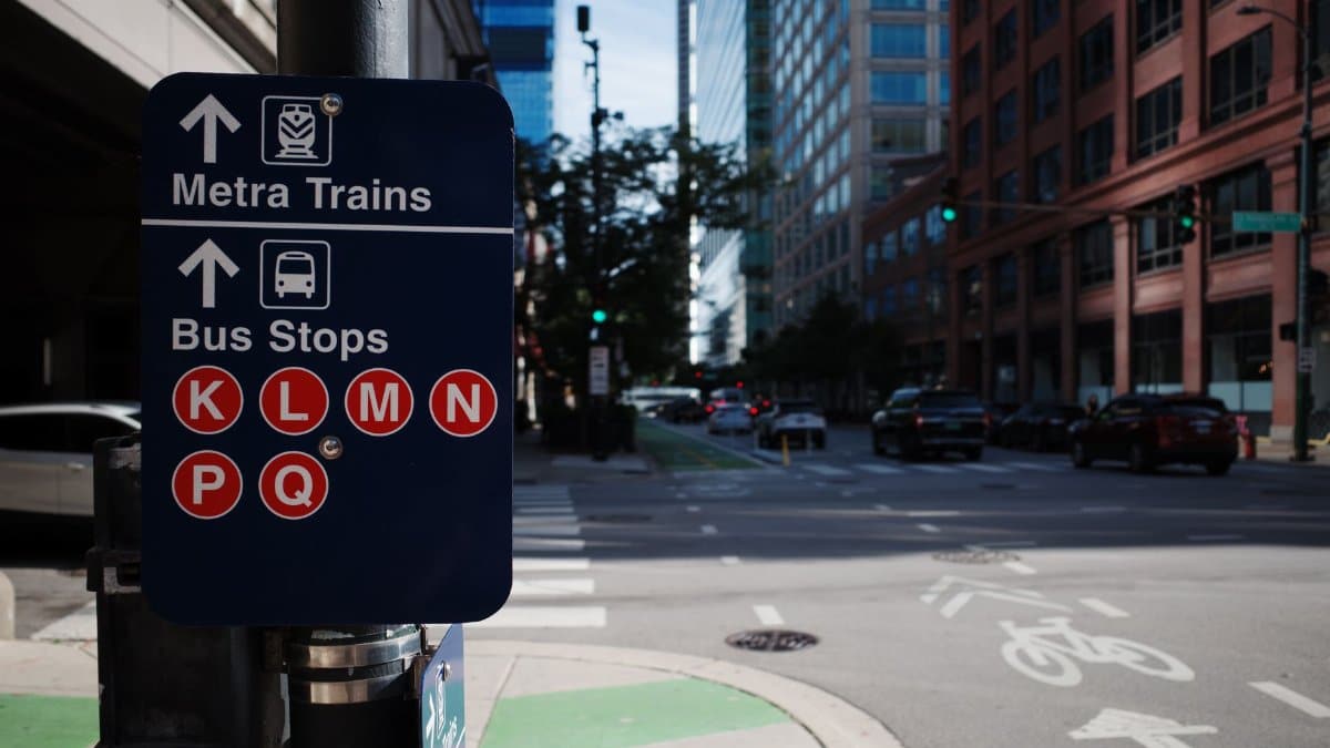 Urban street scene with transit sign for Metra trains and bus stops in downtown city.