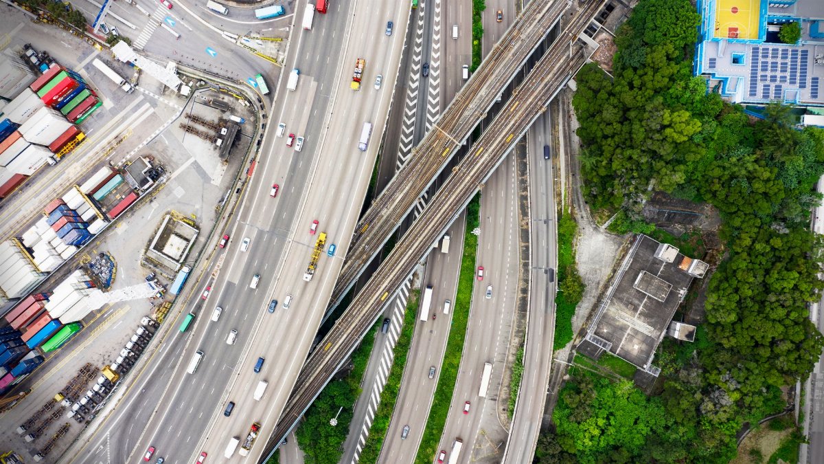 Aerial photo of a busy highway interchange in Hong Kong, showcasing urban infrastructure and traffic flow.