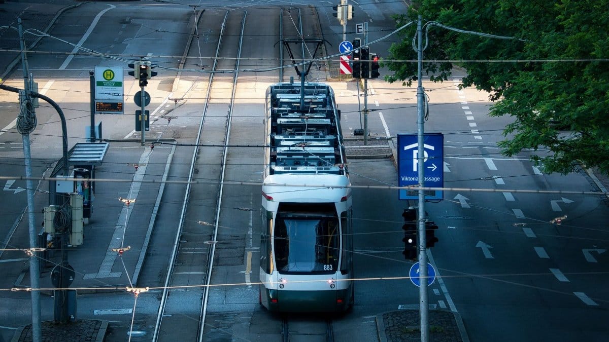 A tram navigates empty streets in Augsburg, Germany, captured during the early morning.